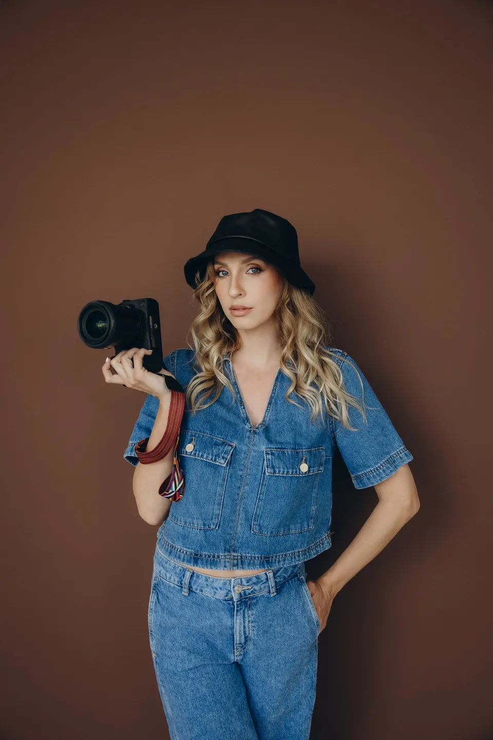 Fotografka Monika Marušáková s fotoaparátom na hnedom pozadí