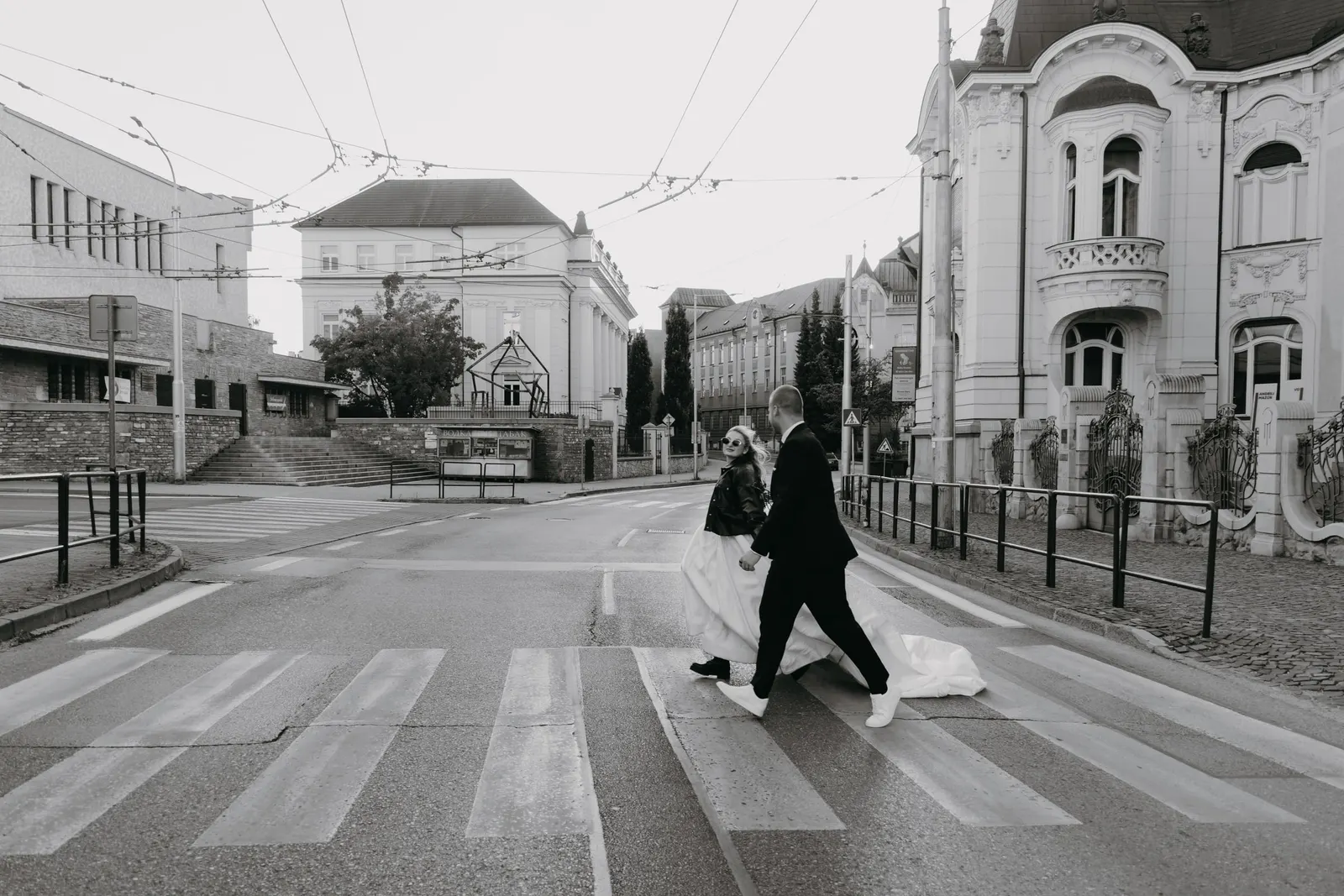 Novomanželia prechádzajú cez priechod pre chodcov v meste