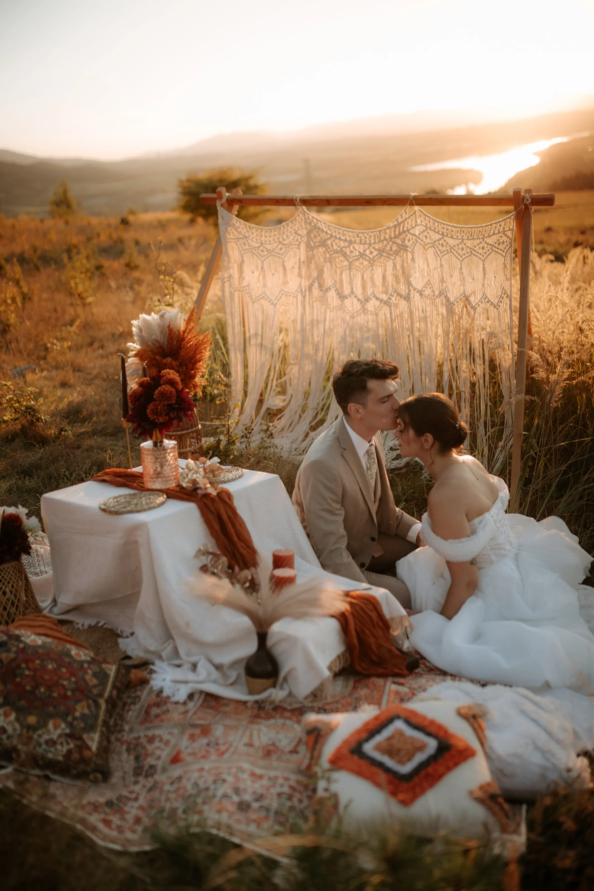 Pár na boho pikniku na lúke pri západe slnka